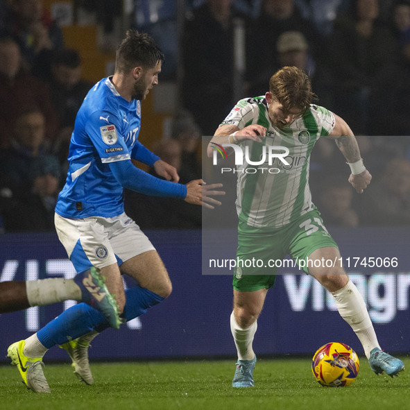 Jasper Pattenden, 31, of Wycombe Wanderers F.C. is tackled by the opponent during the Sky Bet League 1 match between Stockport County and Wy...