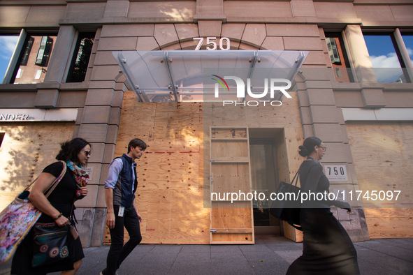 People walk past businesses near the White House that are boarded up in the event of violence following today's election for president in Wa...