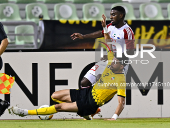 Hossein Goodarzi (bottom) of Sepahan SC battles for the ball with Tyrone Conraad of Sharjah FC during the AFC Champions League Two Group A f...