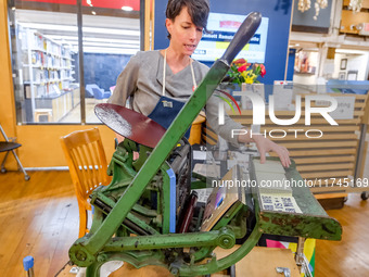 Elysa Voshell, Executive Director of the Minnesota Center for Book Arts, prints postcards using a traditional letterpress for voters to grab...