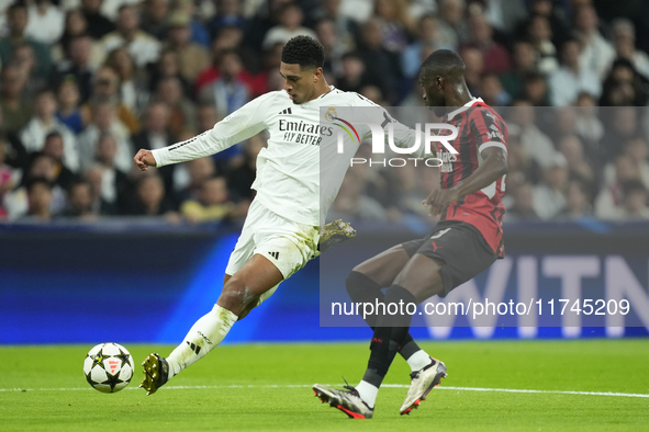 Jude Bellingham central midfield of Real Madrid and England shooting to goal front Fikayo Tomori centre-back of AC Milan and England during...