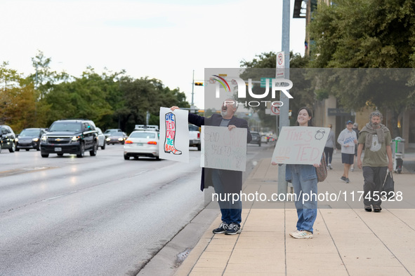 Supporters of Democratic candidate for U.S. Senate Collin Allred hold signs against incumbent Ted Cruz (R-TX) outside the polling place at A...