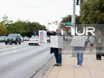 Supporters of Democratic candidate for U.S. Senate Collin Allred hold signs against incumbent Ted Cruz (R-TX) outside the polling place at A...