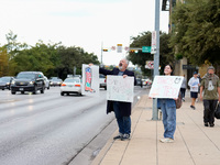 Supporters of Democratic candidate for U.S. Senate Collin Allred hold signs against incumbent Ted Cruz (R-TX) outside the polling place at A...