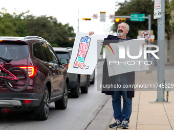 A supporter of Democratic candidate for U.S. Senate Collin Allred holds signs against incumbent Ted Cruz (R-TX) outside the polling place at...