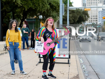 A musician sings to passersby outside the polling place at the Austin City Hall. Voters in the Texas capital meet short lines at most pollin...