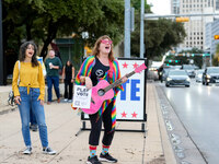 A musician sings to passersby outside the polling place at the Austin City Hall. Voters in the Texas capital meet short lines at most pollin...