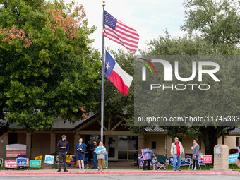 Campaign workers greet voters outside a polling place in suburban Austin, Texas, on November 5, 2024, as poll-goers meet short lines at most...