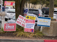 Signs greet voters outside a polling place in suburban Austin, Texas, on the morning of Election Day, as poll-goers meet with short lines at...