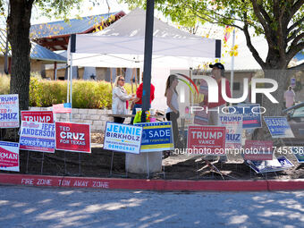 Campaign workers greet voters outside a polling place in suburban Austin, Texas, on November 5, 2024, as poll-goers meet short lines at most...