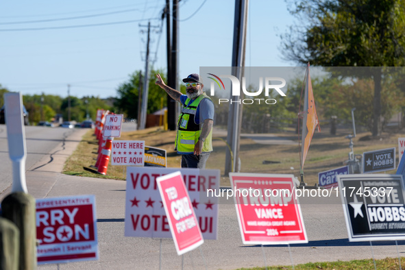 An election worker directs traffic into the parking lot of a polling place in suburban Austin, Texas, on November 5, 2024. Voters across the...