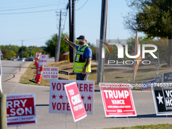 An election worker directs traffic into the parking lot of a polling place in suburban Austin, Texas, on November 5, 2024. Voters across the...