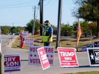 An election worker directs traffic into the parking lot of a polling place in suburban Austin, Texas, on November 5, 2024. Voters across the...