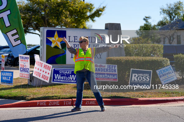 An election worker directs traffic into the parking lot of a polling place in suburban Austin, Texas, on November 5, 2024. Voters across the...