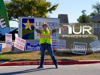 An election worker directs traffic into the parking lot of a polling place in suburban Austin, Texas, on November 5, 2024. Voters across the...