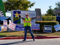 An election worker directs traffic into the parking lot of a polling place in suburban Austin, Texas, on November 5, 2024. Voters across the...