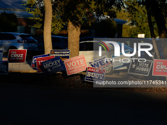 Campaign signs are in the foreground as cars line up to enter a parking lot outside a polling place in suburban Austin, Texas, on November 5...