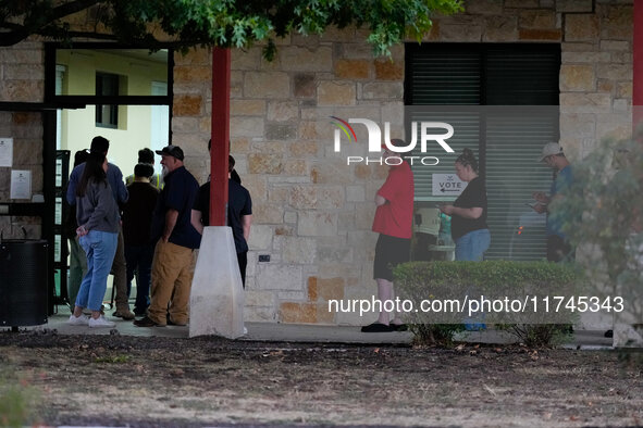 Voters line up outside a polling place in suburban Austin, Texas, on November 5, 2024, in the final hour of voting. Voters across the state...