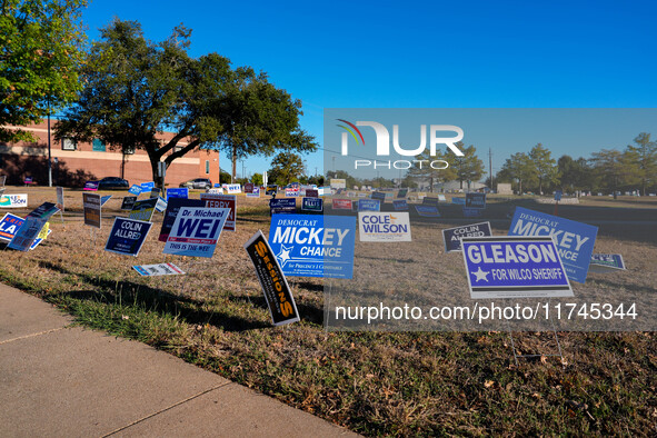 Campaign signs are in the foreground as cars line up to enter a parking lot outside a polling place in suburban Austin, Texas, on November 5...