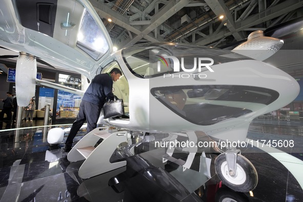 Visitors learn about the technology E20 eVTOL electric vertical take-off and landing vehicle at the 7th CIIE in Shanghai, China, on November...