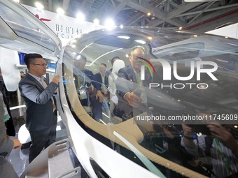 Visitors learn about the technology E20 eVTOL electric vertical take-off and landing vehicle at the 7th CIIE in Shanghai, China, on November...