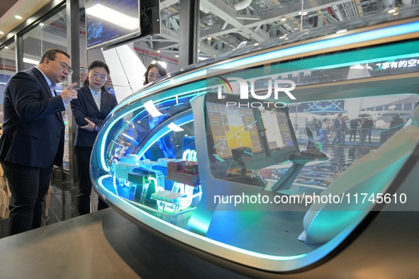 Visitors learn about the E20 eVTOL electric vertical take-off and landing vehicle flight control system at the 7th CIIE in Shanghai, China,...