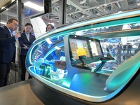 Visitors learn about the E20 eVTOL electric vertical take-off and landing vehicle flight control system at the 7th CIIE in Shanghai, China,...