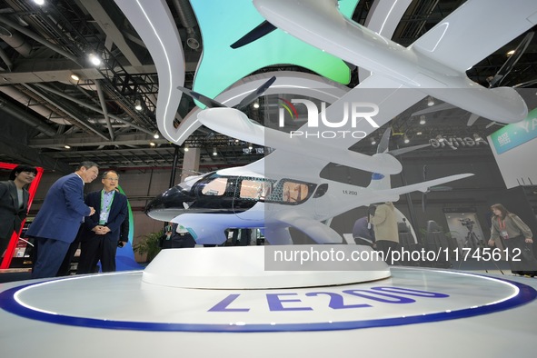 Visitors learn about the LE200 electric vertical take-off and landing passenger aircraft of Yi Airlines at the 7th CIIE in Shanghai, China,...