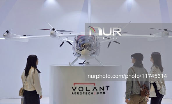 Visitors learn about the Volant Air VE25 electric vertical take-off and landing (VTOL) aircraft at the 7th CIIE in Shanghai, China, on Novem...