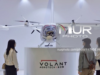 Visitors learn about the Volant Air VE25 electric vertical take-off and landing (VTOL) aircraft at the 7th CIIE in Shanghai, China, on Novem...