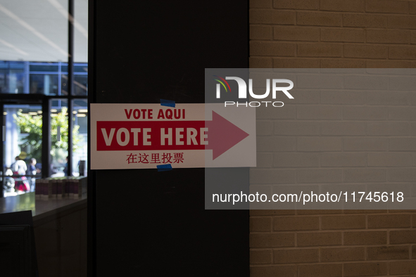 A sign with a pointing arrow is visible while voters stand in a local polling station in Washington, DC, on November 5, 2024. 