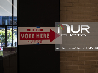 A sign with a pointing arrow is visible while voters stand in a local polling station in Washington, DC, on November 5, 2024. (