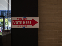 A sign with a pointing arrow is visible while voters stand in a local polling station in Washington, DC, on November 5, 2024. (