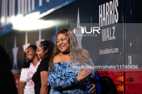 People take selfies with the Harris Walz campaign bus during a watch party for presidential election results featuring Vice President Kamala...