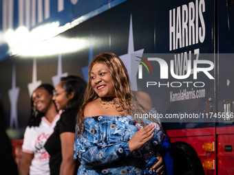 People take selfies with the Harris Walz campaign bus during a watch party for presidential election results featuring Vice President Kamala...