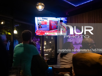 People watch the 2024 election results during a watch party at the Admiral in Washington, DC, on November 5, 2024.  Voters are choosing the...