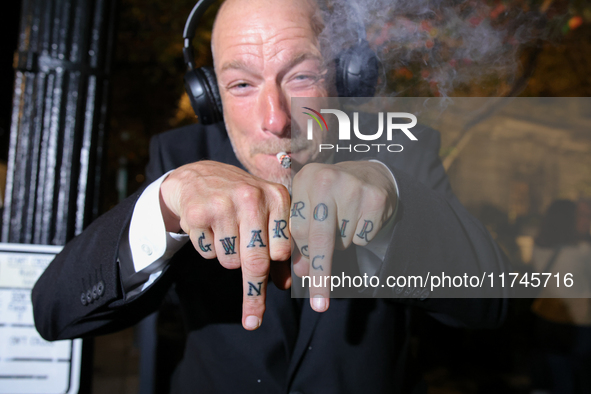 A man displays tattoos while smoking marijuana near the White House in Washington, D.C. on November 5, 2024. 