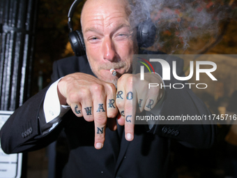 A man displays tattoos while smoking marijuana near the White House in Washington, D.C. on November 5, 2024. (