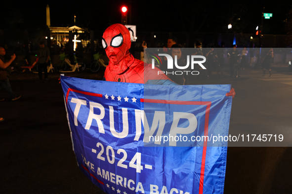 A supporter of presidential candidate Donald Trump holds a flag near the White House in Washington, D.C. on November 5, 2024 as presidential...