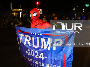 A supporter of presidential candidate Donald Trump holds a flag near the White House in Washington, D.C. on November 5, 2024 as presidential...