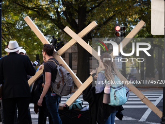 People carry large crosses to the White House on Election Day in Washington, DC, on November 5, 2024.  Americans determine whether Vice Pres...