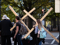 People carry large crosses to the White House on Election Day in Washington, DC, on November 5, 2024.  Americans determine whether Vice Pres...