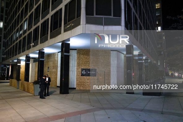 People stand near boarded up buildings near the White House in Washington, D.C. on November 5, 2024 as results are tallied for the president...