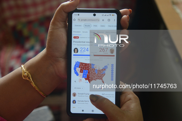 A lady looks at and checks the 2024 US presidential election poll results on her cellphone in Siliguri, India, on November 6, 2024. 