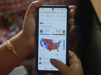 A lady looks at and checks the 2024 US presidential election poll results on her cellphone in Siliguri, India, on November 6, 2024. (