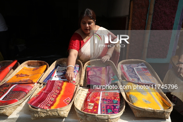 A woman arranges free religious materials to distribute to devotees who perform prayers ahead of the Hindu religious festival of Chhat Puja...