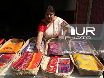 A woman arranges free religious materials to distribute to devotees who perform prayers ahead of the Hindu religious festival of Chhat Puja...