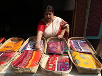 A woman arranges free religious materials to distribute to devotees who perform prayers ahead of the Hindu religious festival of Chhat Puja...