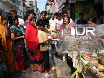 Devotees collect free religious material to perform prayers ahead of the Hindu religious festival of Chhat Puja in Kolkata, India, on Novemb...