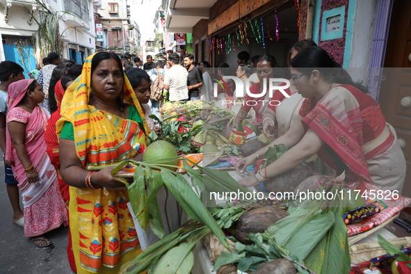 A devotee collects free religious material to perform prayers ahead of the Hindu religious festival of Chhat Puja in Kolkata, India, on Nove...